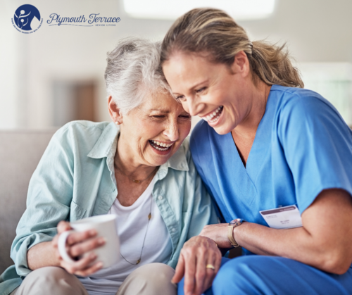 An older woman and her caregiver laughing